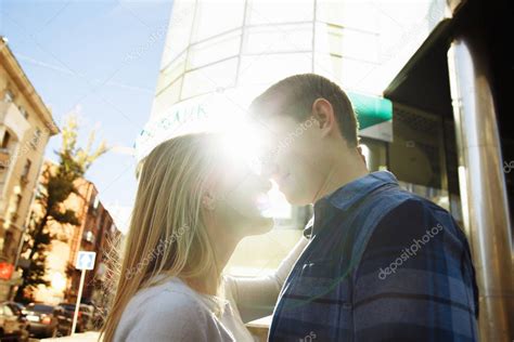 Портрет счастливой пары обнимающейся на улице в городе Стоя лучше от солнца яркий свет