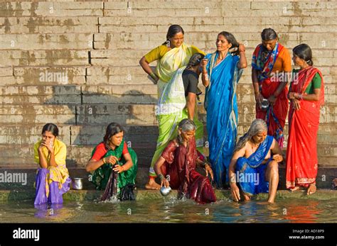 A Group Of Indian Women Wearing Colourful Saris Perform Their Daily