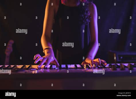 Mid Section Of Female Musician Playing Piano While Performing In