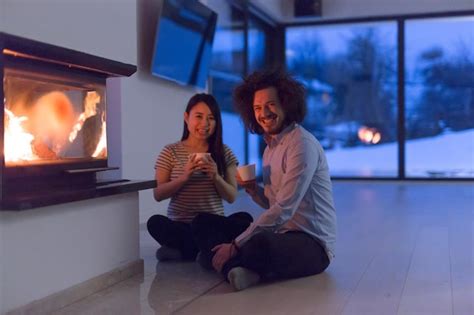 Premium Photo Young Romantic Multiethnic Couple Sitting On The Floor In Front Of Fireplace At