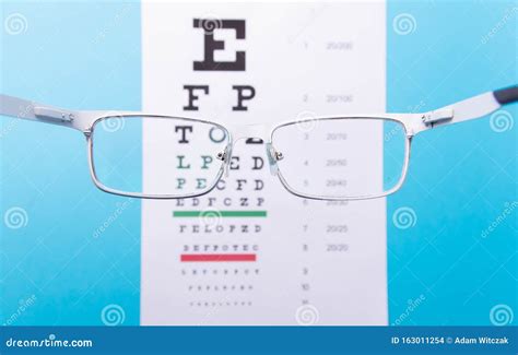 Hand Held Glasses View Of The Snellen Chart Blue Background Stock