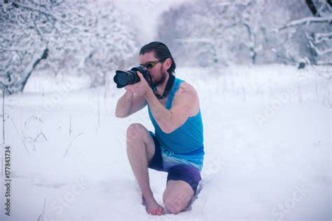 Naked Man With Camera Sit In The Winter Forest Stock Photo And