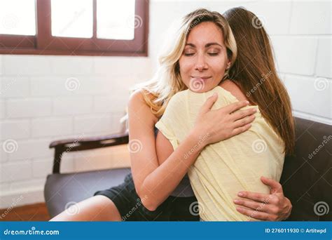 Happy Caucasian Lesbian Couple Cuddling Each Other With A Smile And