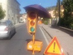 Sul semaforo spunta l’ombrello perché i colori non sono visibili ...