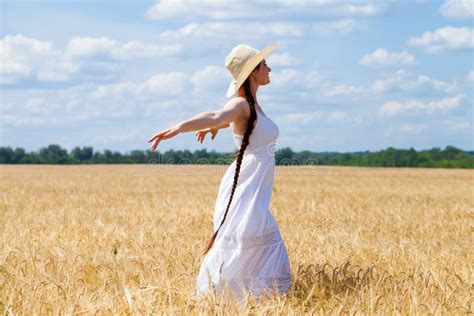 Young Brunette Woman In White Dress Walking In A Wheat Field Stock