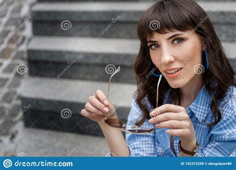 The Girl Took Off Her Glasses And Sits On The Steps Portrait Of A