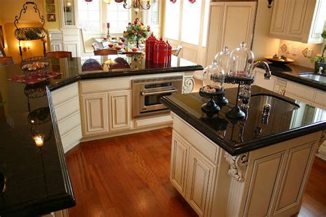 Whether you choose to go with a light or dark this dark hardwood floor is matched wonderfully by the dark center island. black counters, cream cabinets, wood floors. Love everything about this. | Black granite ...