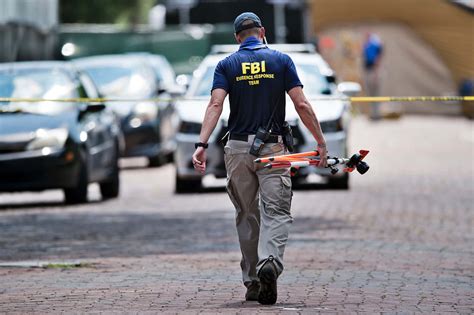 Download Fbi Agent Walks Down A Street With A Drone Wallpaper