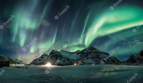 Aurora Borealis Or Northern Lights Over Snow Mountain On