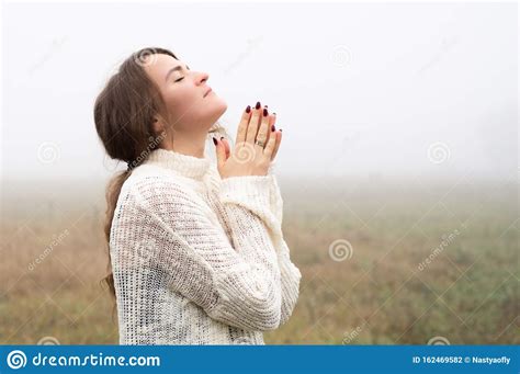 Girl Closed Her Eyes Praying In A Field During Beautiful Fog Hands
