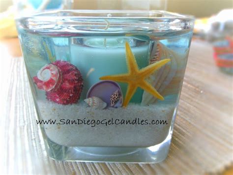 A Candle That Is Sitting On A Table With Shells And Starfishs In It