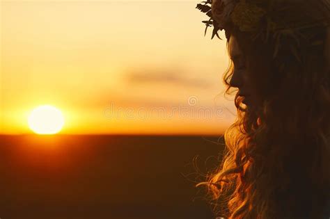 Beautiful Blonde Model Girl With Curly Hair And With A Floral Wreath On Her Head Posing At The