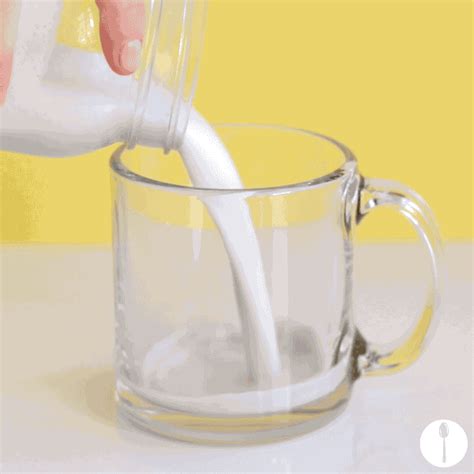 A Person Pouring Milk Into A Glass Mug