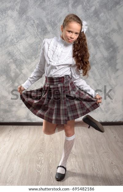 Schoolgirl School Uniform Posing On Light Stock Photo