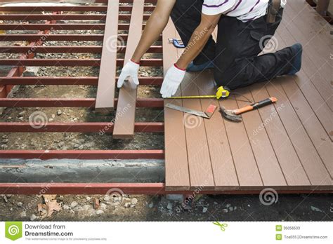 When we first moved into our house, i had stained my concrete back patio and over the years is did. Worker Installing Wood Floor For Patio Stock Photos ...