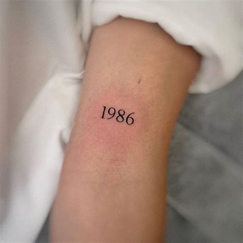 1986 Lettering Tattoo On The Bicep