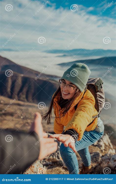 People Helping Each Other Hike Up A Mountain At Sunrise Stock Image