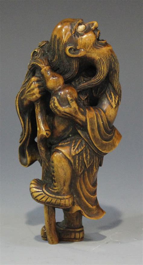 a japanese carved wood okimono netsuke 20th century finely modelled as a blind beggar carrying a
