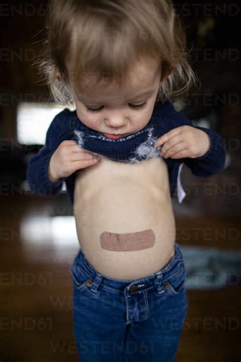 Toddler Girl With Bandaid On Stomach Stock Photo