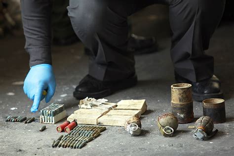 An Explosive Ordnance Disposal Officer Inspects Three Hand Grenades And 225 Rounds Of Assorted