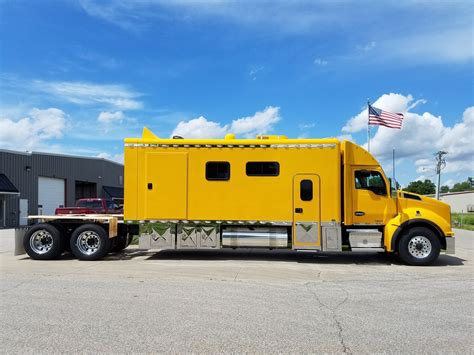 A Yellow Truck Is Parked In Front Of A Building With An American Flag On It