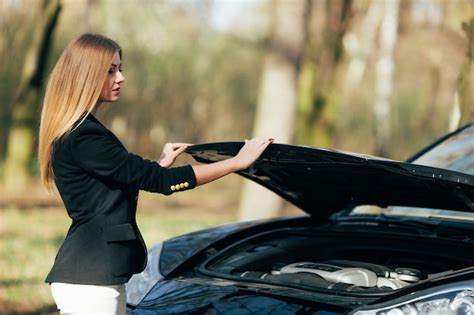 uma mulher espera por assistência perto de seu carro quebrado na beira da estrada foto grátis