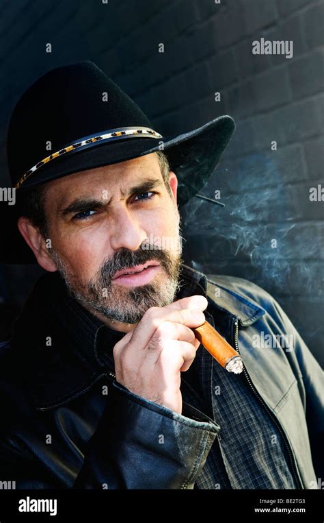 Man With Beard In Cowboy Hat Smoking Cigar Stock Photo Alamy