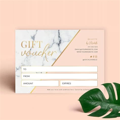 A Pink And Gold Gift Voucher Card With A Green Leaf Next To It On A
