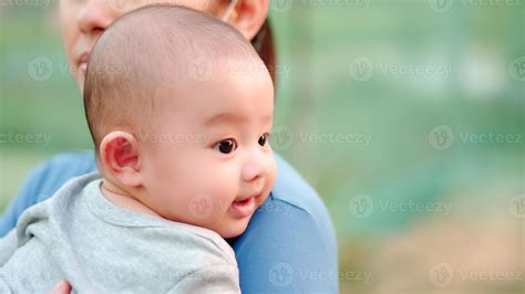 lindo bebé asiático recién nacido con cara feliz sonriente familia feliz la joven madre