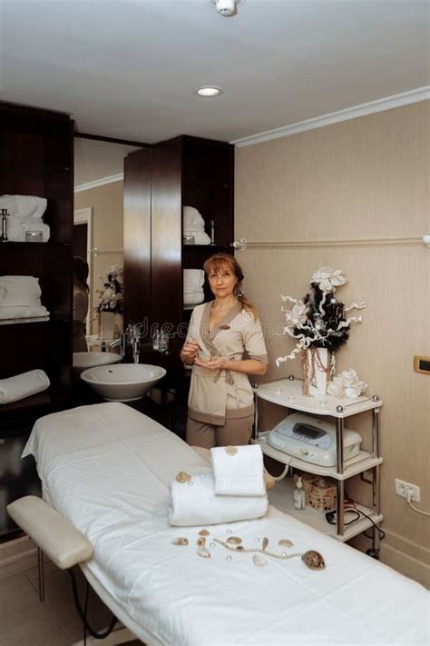 Female Massage Therapist Stands Near The Massage Table And Prepares To