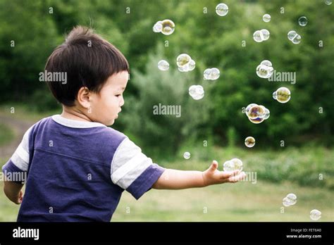 Cute Boy Playing With Bubbles In Park Stock Photo Alamy