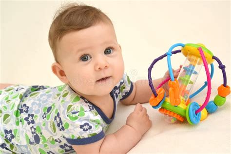 Portrait Of The Baby With A Toy On A Light Background Stock Photo
