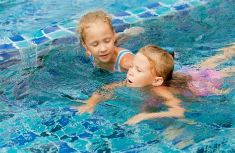 Two Happy Little Girls Splashing Around In The Pool ⬇ Stock Photo