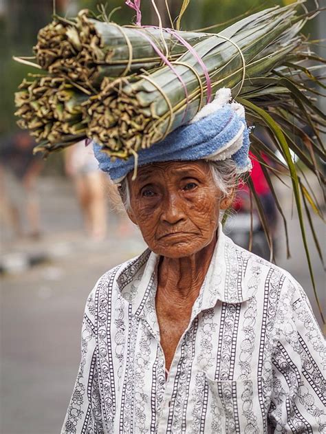 old woman carries palm leaves on her head ubud bali indonesia southeast asia asia bali