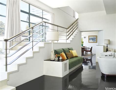 A Living Room Filled With Furniture Next To A Stair Case In Front Of A