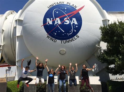 Four People Jumping In The Air With Their Hands Up And Arms Wide Open