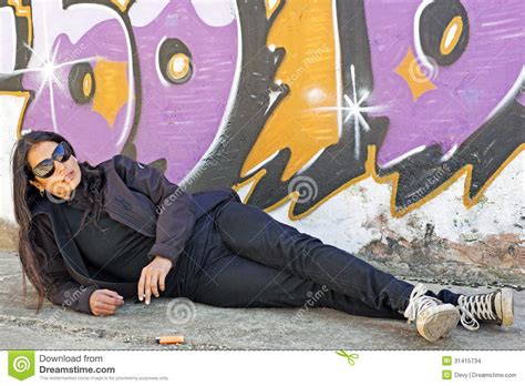 Smoking Woman At The Graffiti Brick Wall Stock Photo