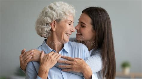 Smiling Adult Daughter And Senior Mother Hug At Home Stock Image Image Of Looking Embrace