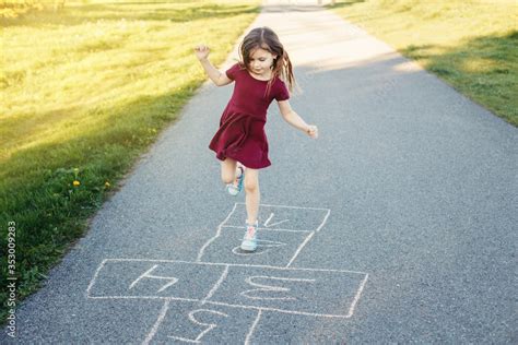 Cute Adorable Little Young Chld Girl Playing Hopscotch Outdoors Funny