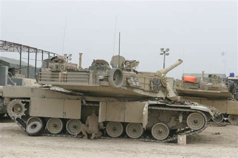 A Us Marine Performs Maintenance On A M1a1 Abrams Tank In Camp