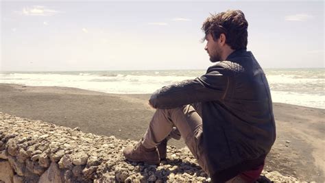 Sad Depressed Young Man Sitting By The Sea Stock Footage Video 3885767