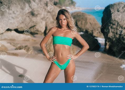 Beautiful Tanned Woman In Separate Swimsuit Posing On Beach And Looking