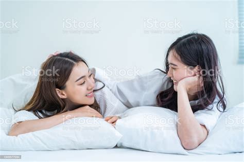 asian beautiful lesbian couple wake up from sleep in bedroom in morning attractive gay girl