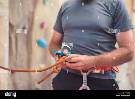 Rock Wall Climber Wearing Safety Harness And Climbing Equipment Indoor