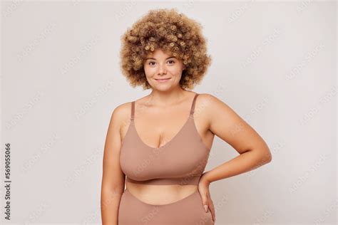 Foto De Horizontal Shot Of Busty Body Positive Woman With Curly Hair Looks Confident And Self
