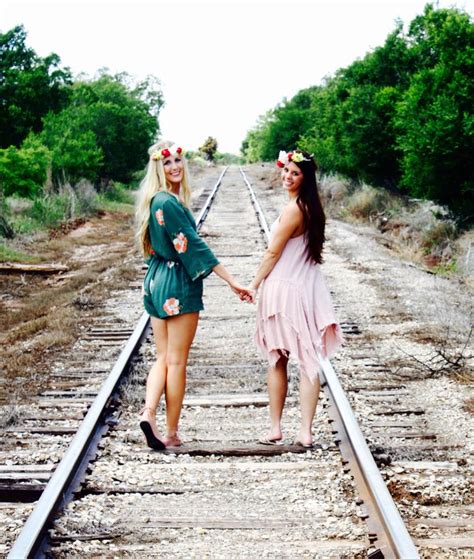 Two Women Standing On Train Tracks Holding Hands