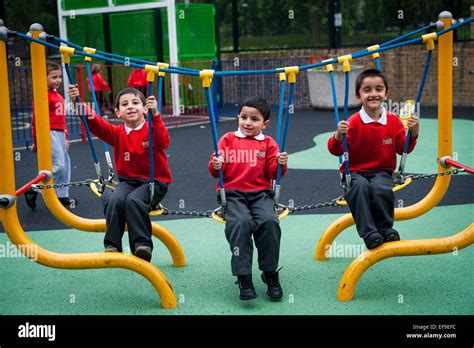 Happy Smiling Children Playing In The Playground Of Primary School In