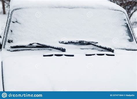 Car Windshield Wipers And Windscreen In Snow Closeup Stock Photo