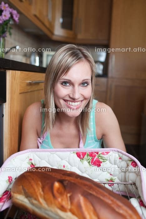 Cheerful Blond Woman Baking Bread In A Kitchen