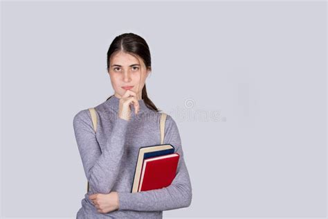 Thoughtful Student Girl Portrait Holding Textbooks Looking Puzzled